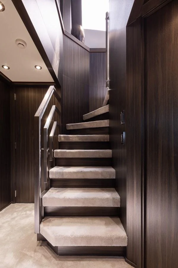A luxurious staircase with plush carpeting and elegant wooden paneling. aboard TAIMARE Yacht for Sale