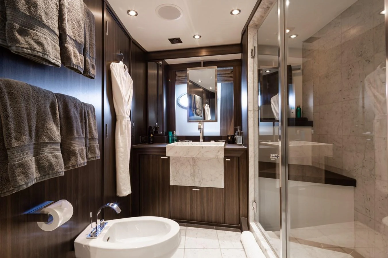 The yacht's bathroom features elegant wood cabinetry and modern fixtures. aboard TAIMARE Yacht for Sale