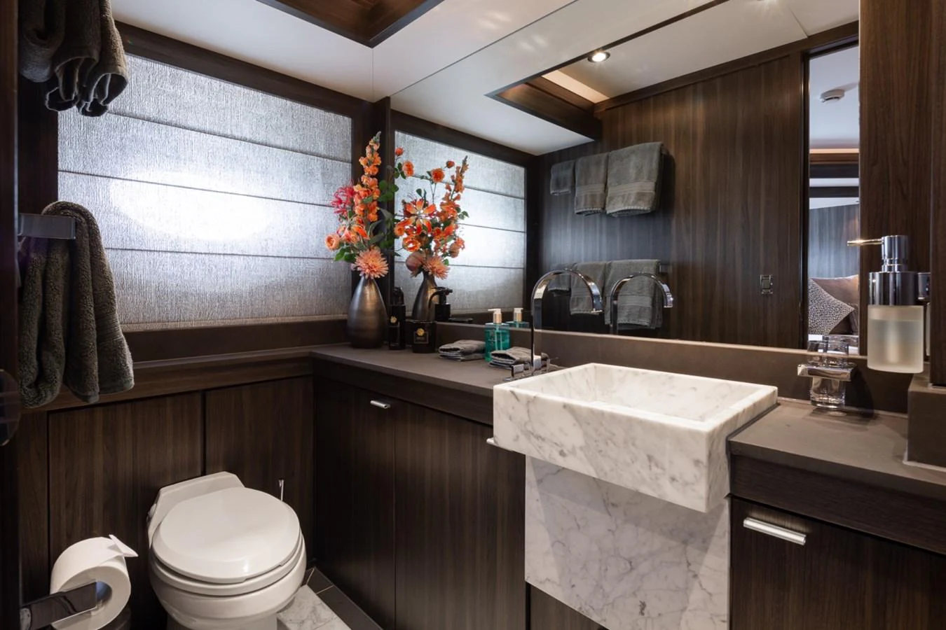 A luxurious yacht bathroom featuring elegant wood paneling and modern fixtures. aboard TAIMARE Yacht for Sale
