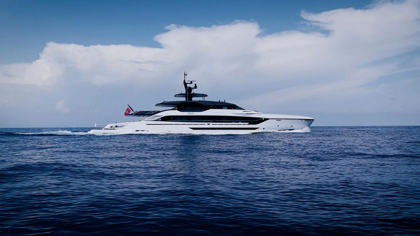 A sleek and modern yacht cruises through calm waters under a bright sky. aboard LOEWE Yacht for Sale