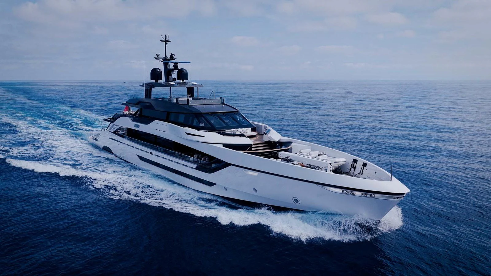 A sleek and modern yacht cruising through open waters under a clear sky. aboard LOEWE Yacht for Sale