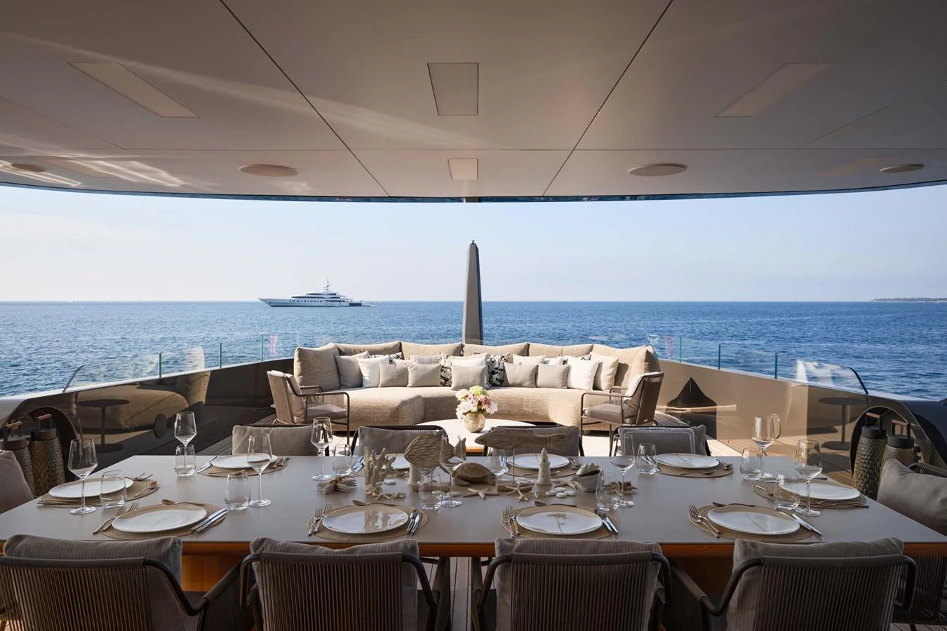 The aft deck offers a luxurious dining area with a stunning ocean view. aboard LOEWE Yacht for Sale