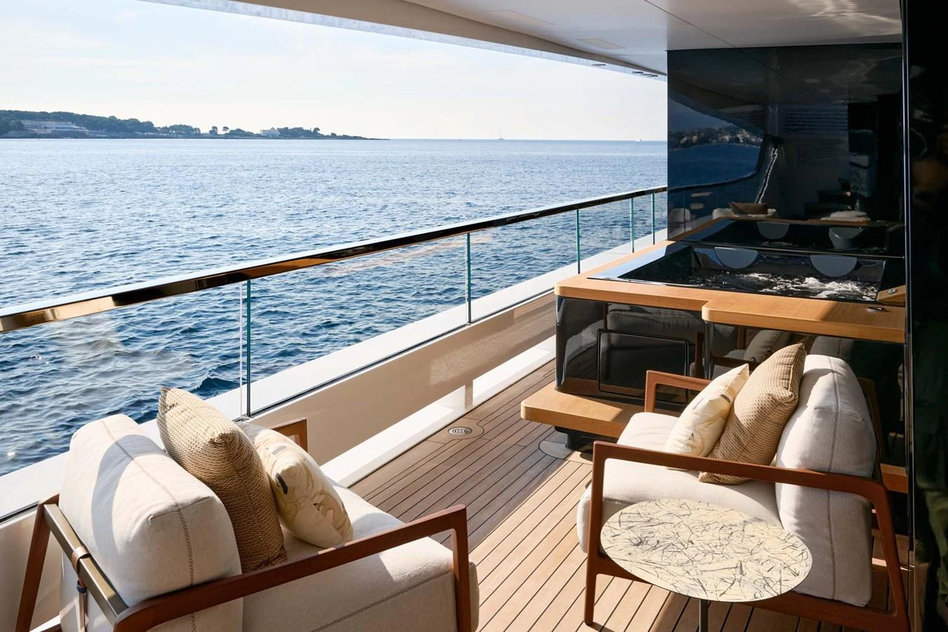 The aft deck offers a serene seating area with comfortable chairs and a stunning ocean view. aboard LOEWE Yacht for Sale
