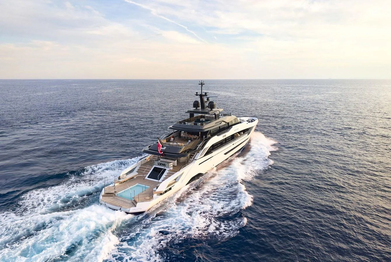 A sleek yacht cruising through open waters, showcasing its luxurious design and spacious deck areas. aboard LOEWE Yacht for Sale