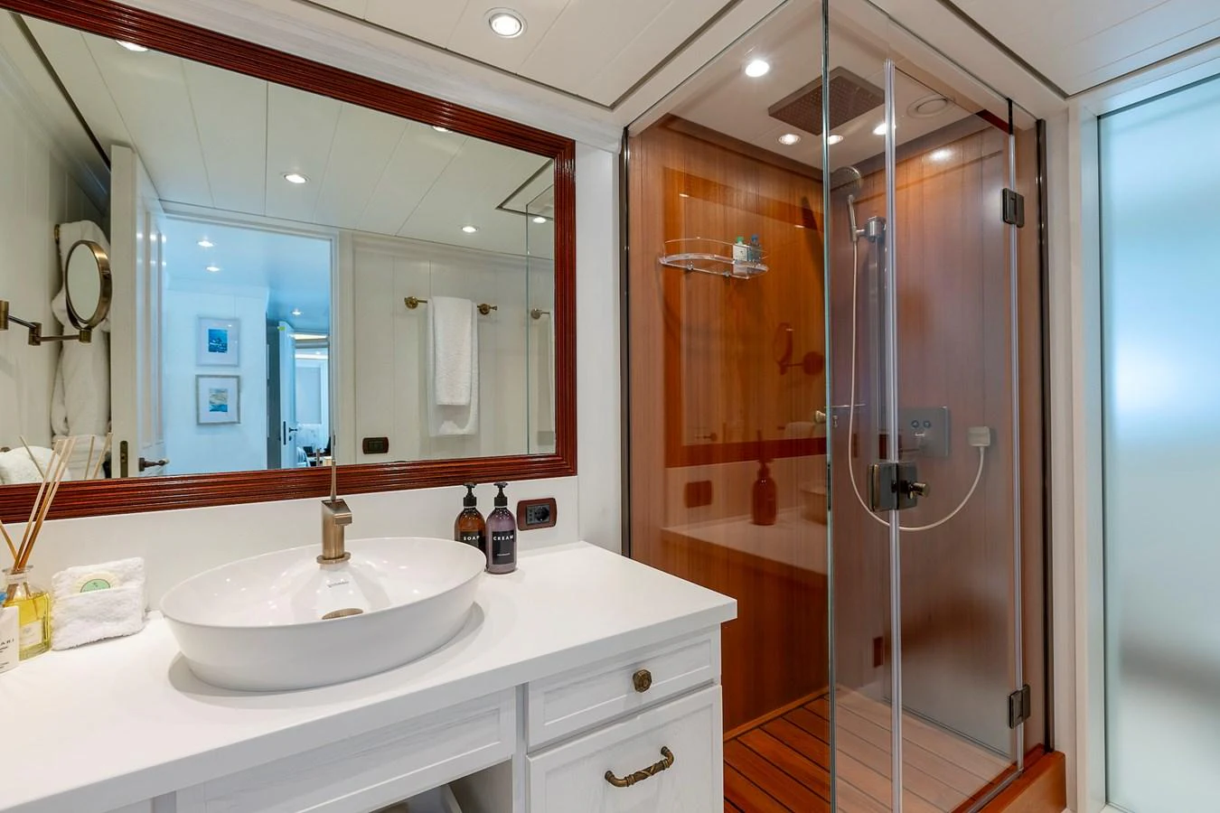 The yacht's bathroom features a modern sink, a spacious shower, and elegant wooden accents. aboard LADY TRUDY Yacht for Sale
