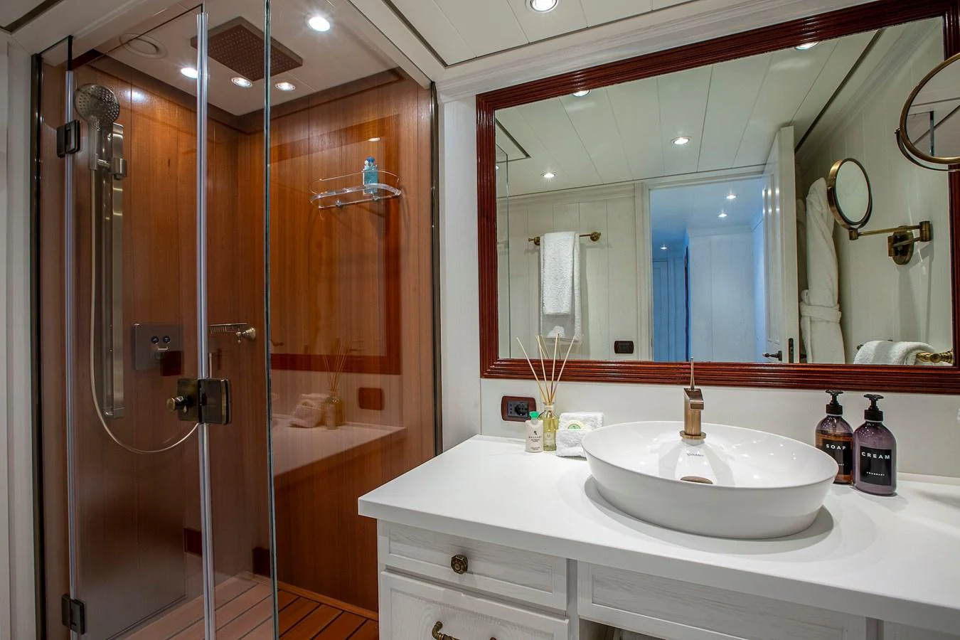 The yacht's bathroom features a modern shower and elegant sink area with ample lighting. aboard LADY TRUDY Yacht for Sale