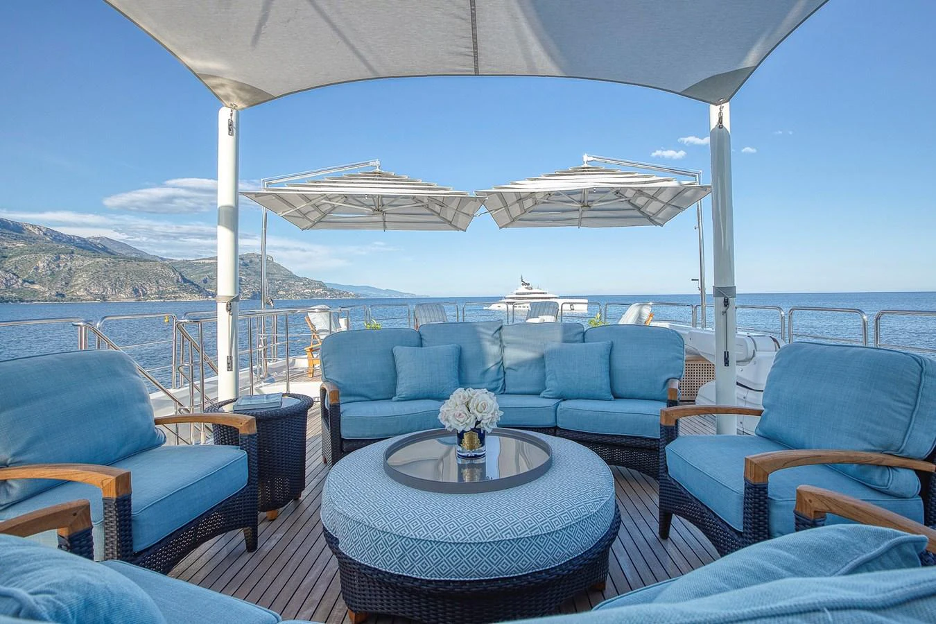 The sundeck offers a luxurious seating area with plush blue cushions and a stunning ocean view. aboard LADY TRUDY Yacht for Sale