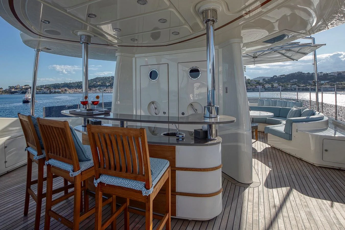 The aft deck features a stylish bar area with wooden stools and a comfortable seating arrangement, perfect for relaxation and socializing. aboard LADY TRUDY Yacht for Sale