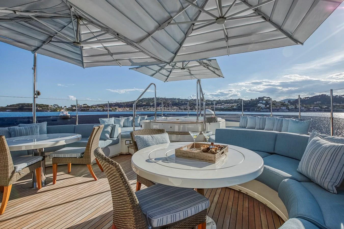 The sundeck offers a luxurious outdoor seating area with tables and umbrellas, perfect for enjoying the view. aboard LADY TRUDY Yacht for Sale