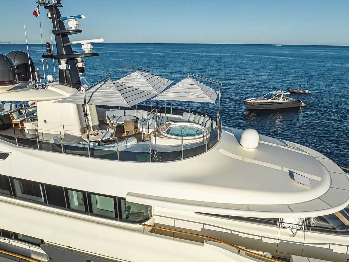 The yacht's sundeck features a luxurious hot tub surrounded by sun loungers and parasols, offering a perfect relaxation spot with stunning sea views. aboard LADY TRUDY Yacht for Sale