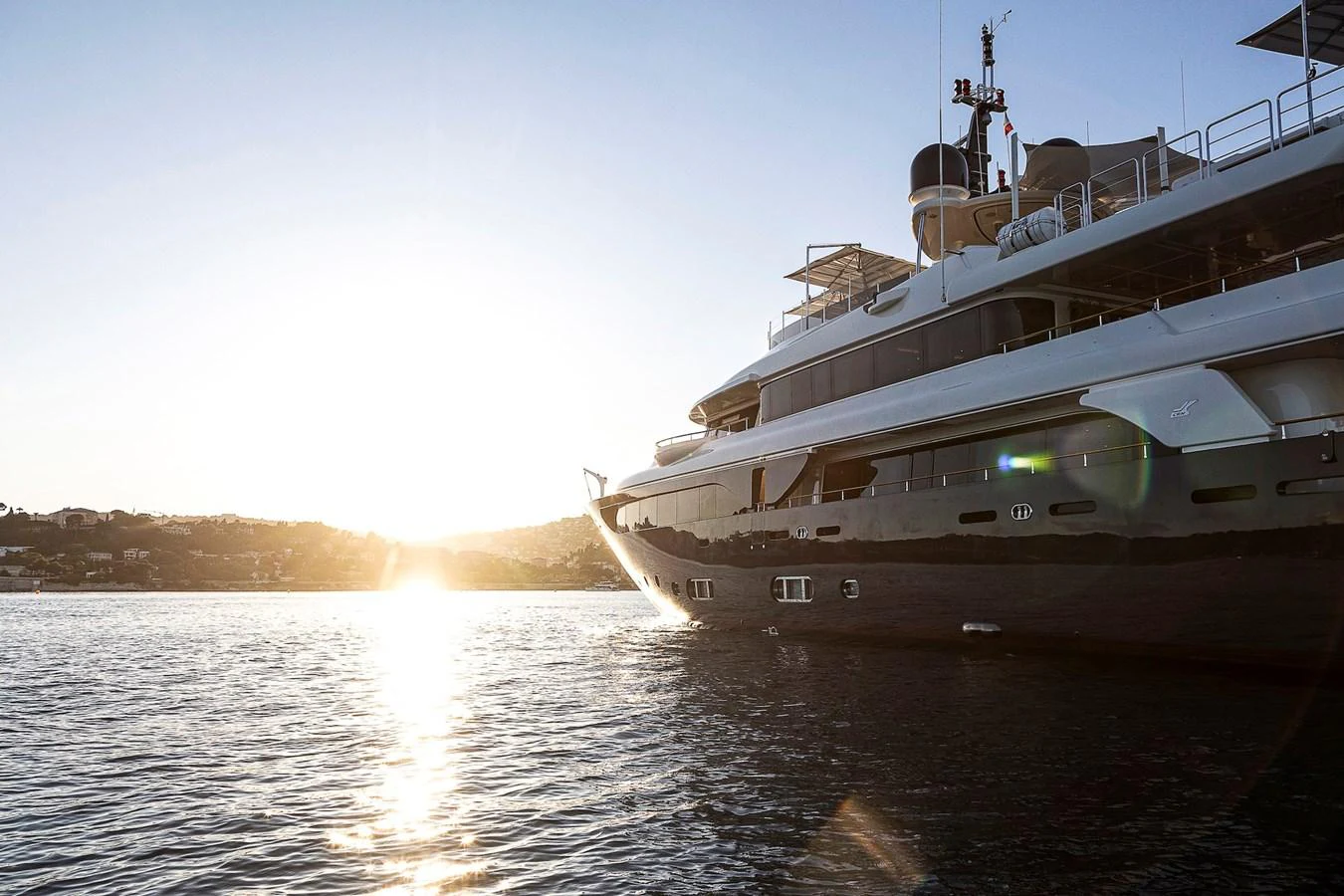A luxurious yacht glides through calm waters at sunset. aboard LADY TRUDY Yacht for Sale