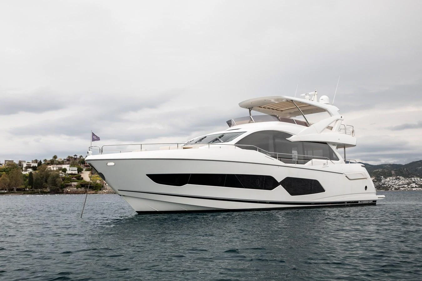 A sleek and modern yacht cruising on calm waters with a scenic backdrop. aboard ANM Yacht for Sale