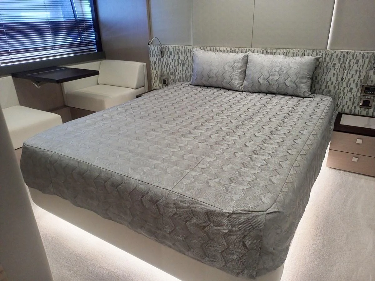 The stateroom features a comfortable bed with elegant bedding and modern decor. aboard ANM Yacht for Sale