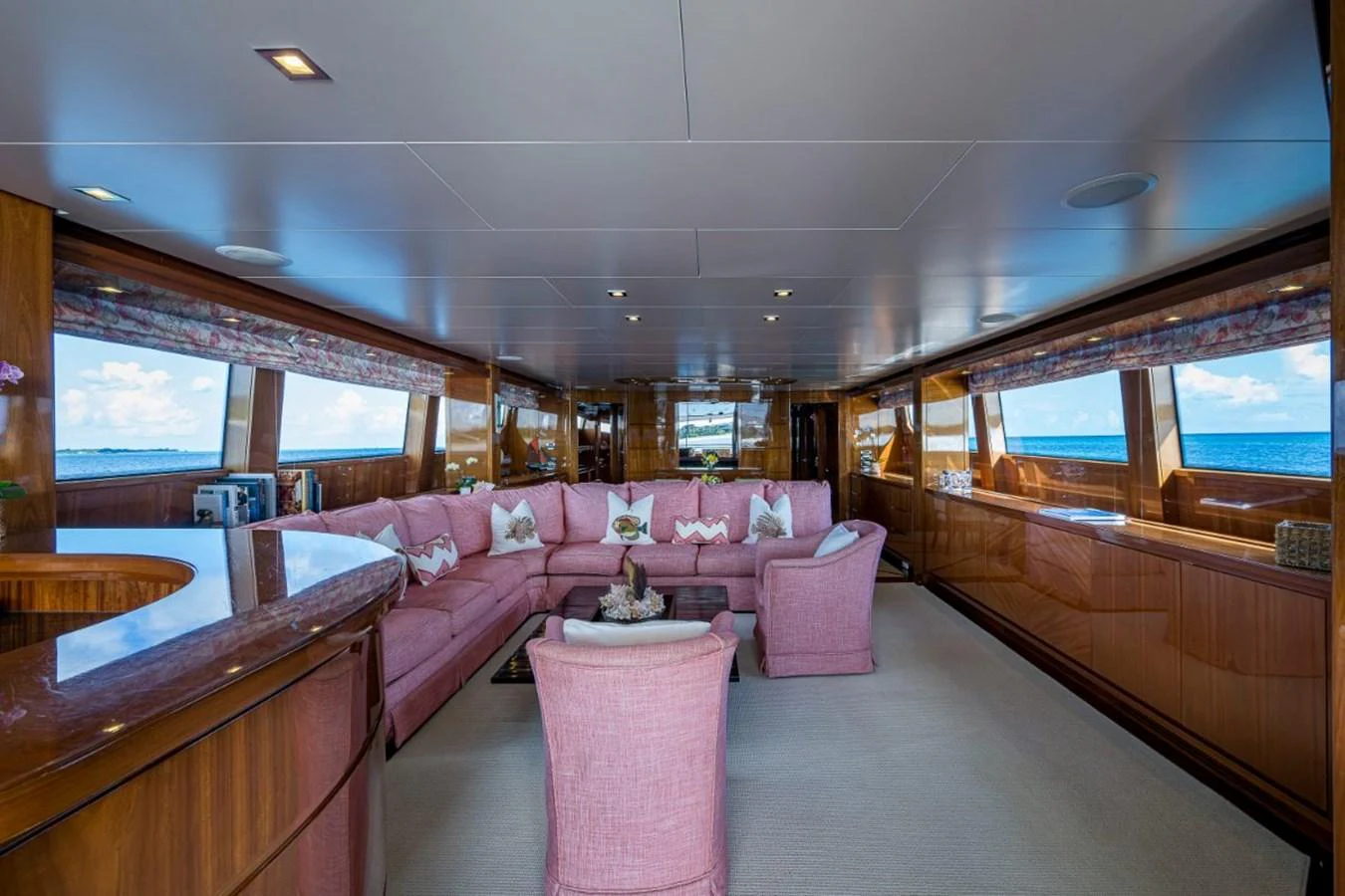 The salon features plush seating with panoramic windows offering stunning ocean views. aboard ALEGHI Yacht for Sale