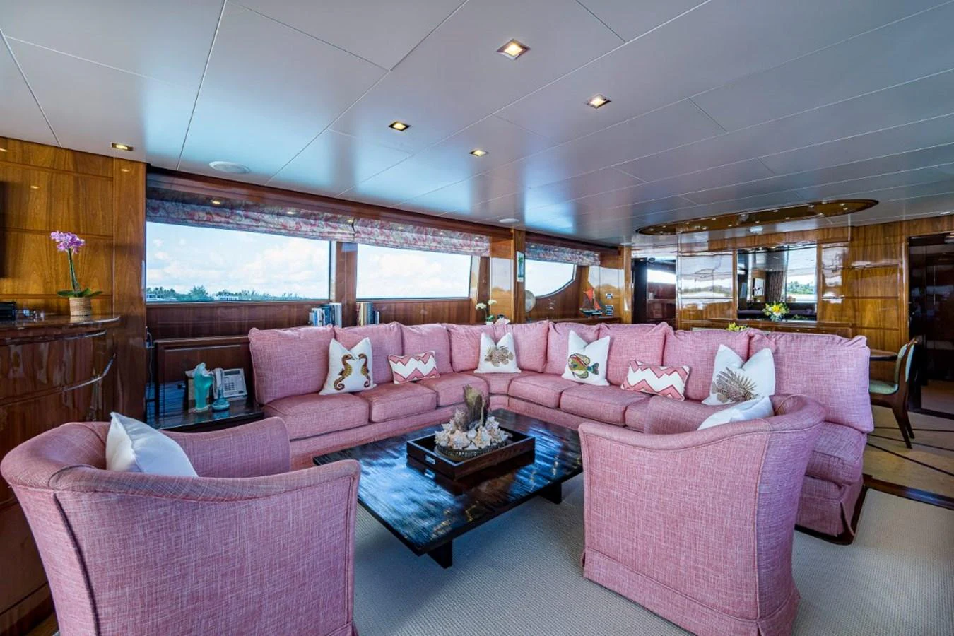 The salon features a spacious seating area with plush pink sofas and large windows offering panoramic views. aboard ALEGHI Yacht for Sale