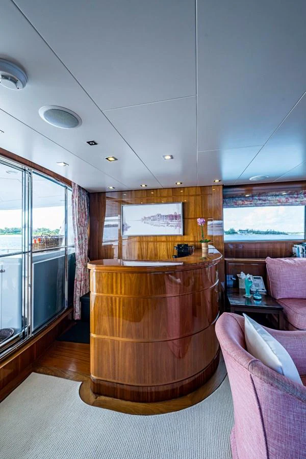 The yacht's salon features elegant wood paneling and comfortable seating with a view of the water. aboard ALEGHI Yacht for Sale