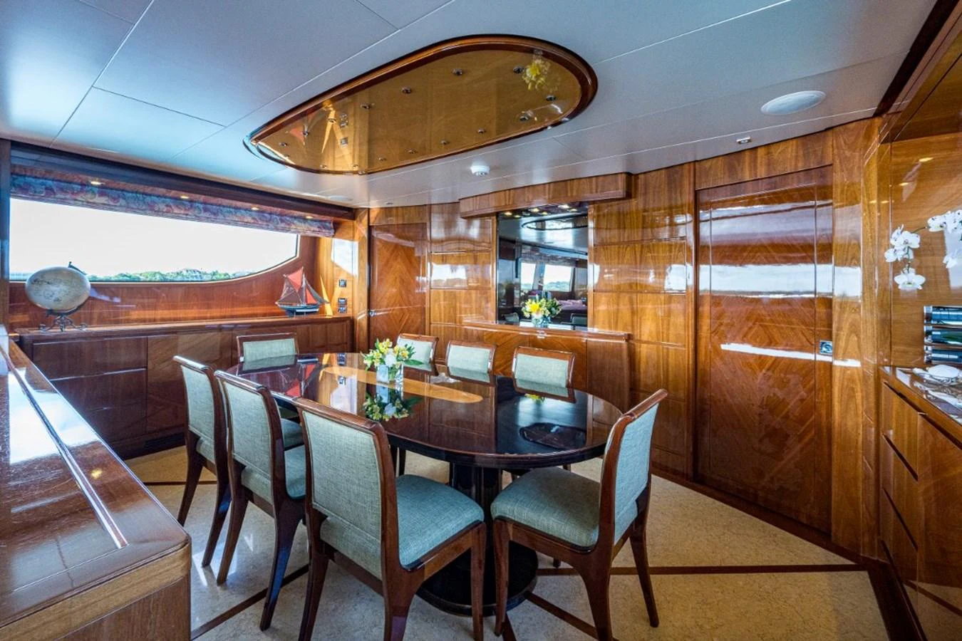 The yacht's dining area features elegant wooden paneling and a large window offering scenic views. aboard ALEGHI Yacht for Sale