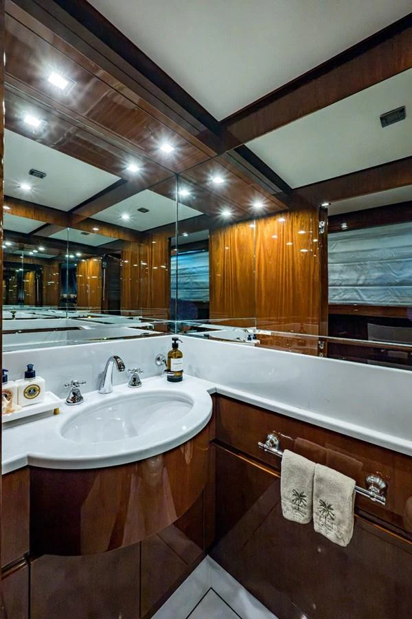 The yacht's bathroom features elegant wood paneling and a sleek, modern sink area. aboard ALEGHI Yacht for Sale