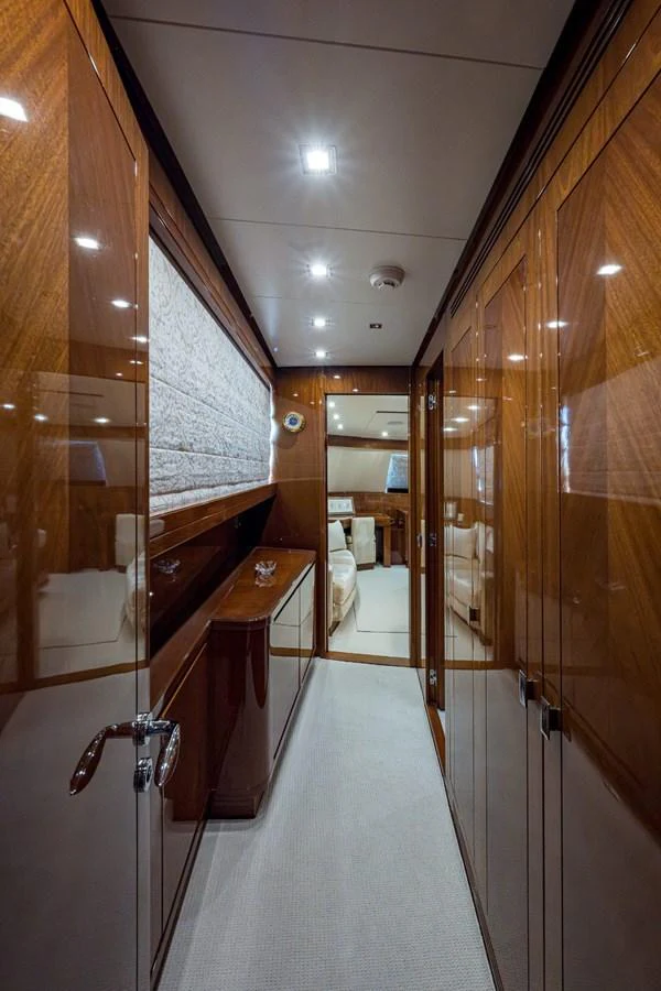 A luxurious hallway with polished wood paneling leads to a cozy seating area. aboard ALEGHI Yacht for Sale
