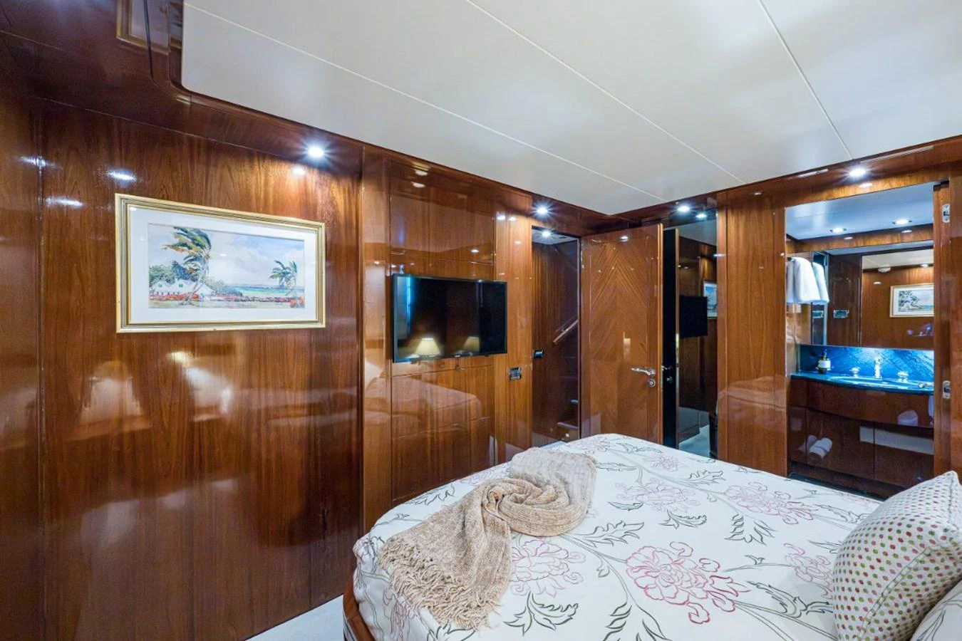 The stateroom features elegant wood paneling and a cozy bed with floral bedding. aboard ALEGHI Yacht for Sale