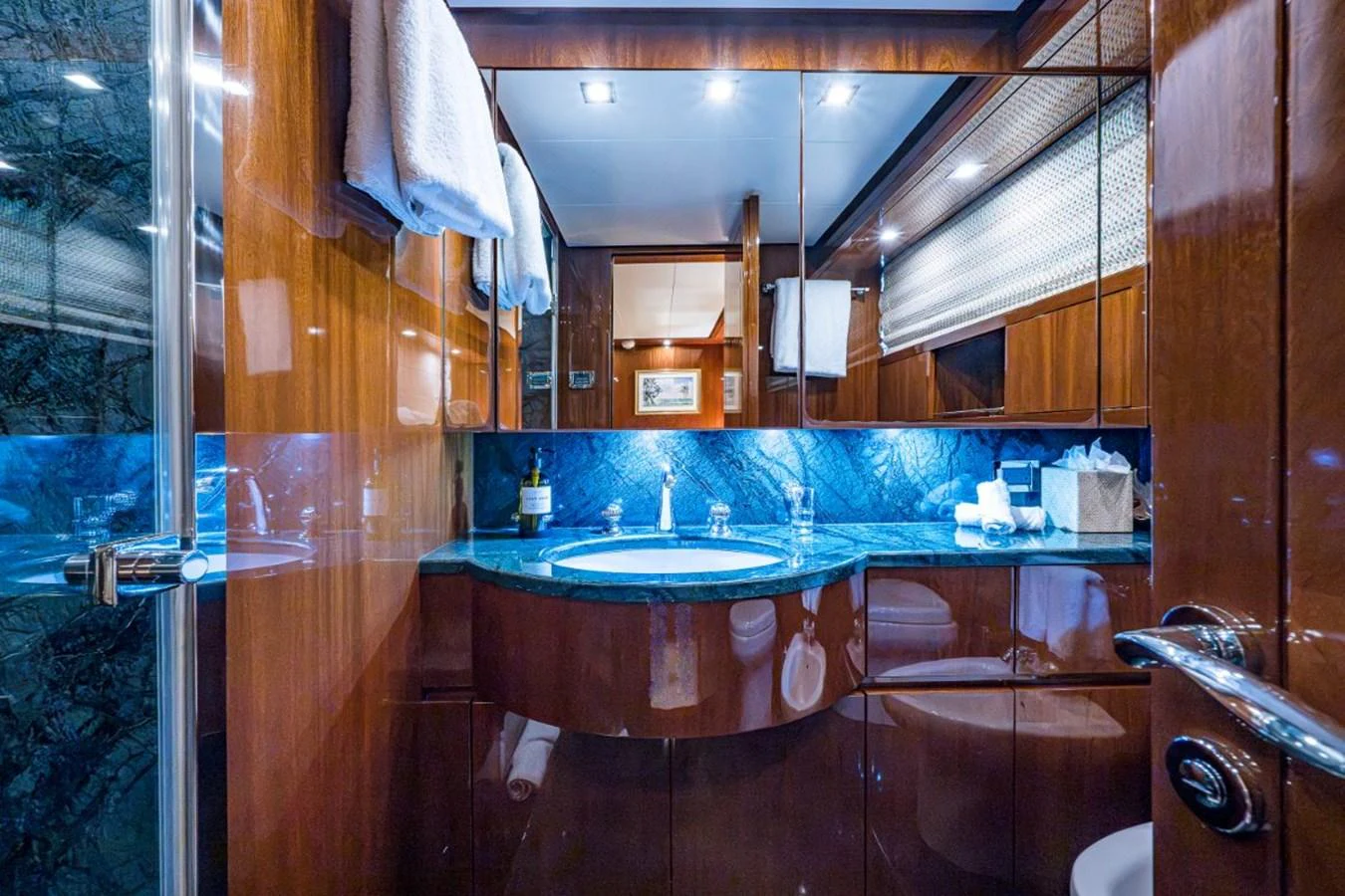 The yacht's bathroom features elegant wooden cabinetry and a luxurious marble countertop. aboard ALEGHI Yacht for Sale