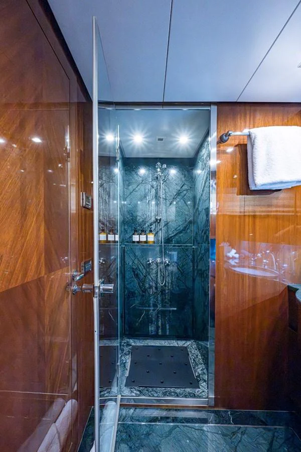 The yacht's bathroom features a luxurious glass-enclosed shower with elegant dark marble accents. aboard ALEGHI Yacht for Sale