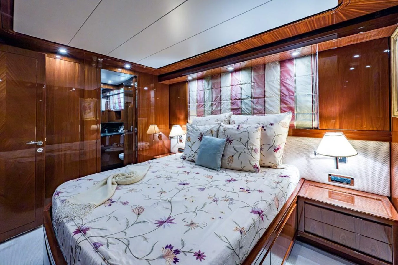 A luxurious stateroom featuring a comfortable bed with elegant bedding and warm lighting. aboard ALEGHI Yacht for Sale
