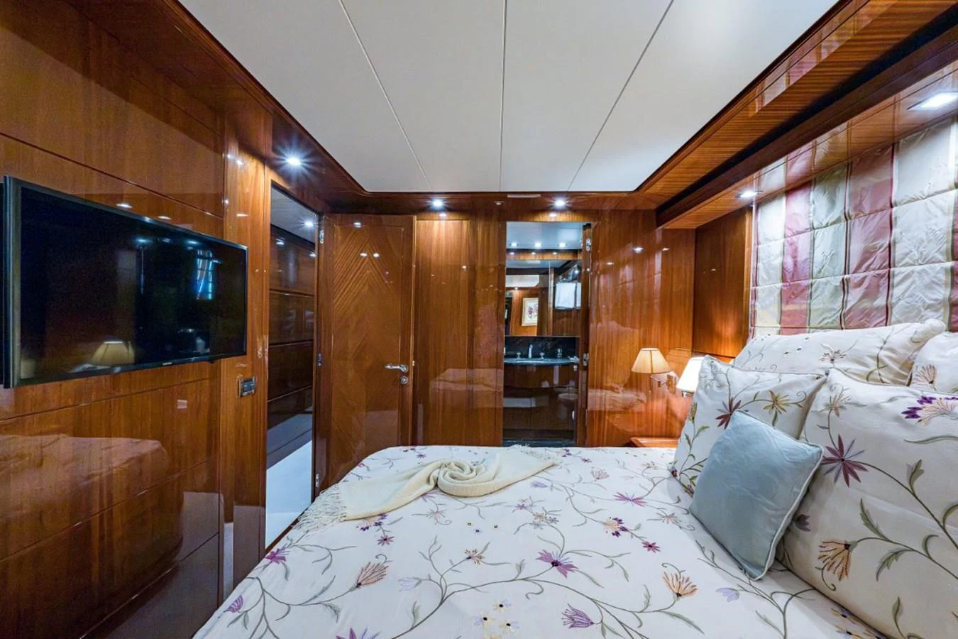The stateroom features luxurious wood paneling and a comfortable bed with floral bedding. aboard ALEGHI Yacht for Sale