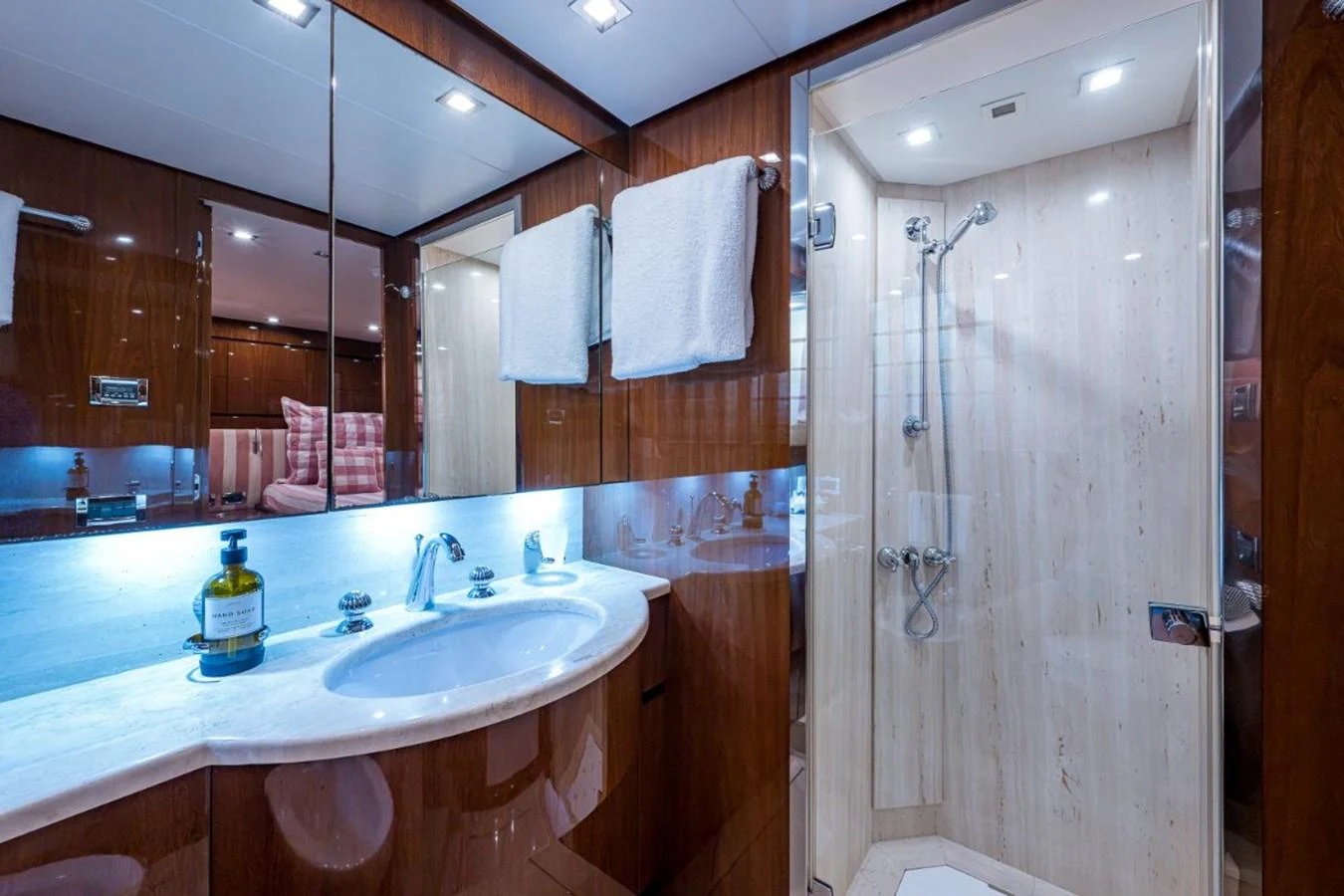 The yacht's bathroom features a luxurious shower and elegant vanity with ample lighting. aboard ALEGHI Yacht for Sale