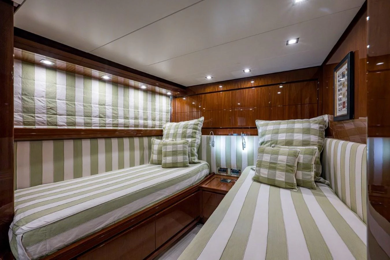 The guest stateroom features twin beds with striped bedding and polished wood finishes. aboard ALEGHI Yacht for Sale