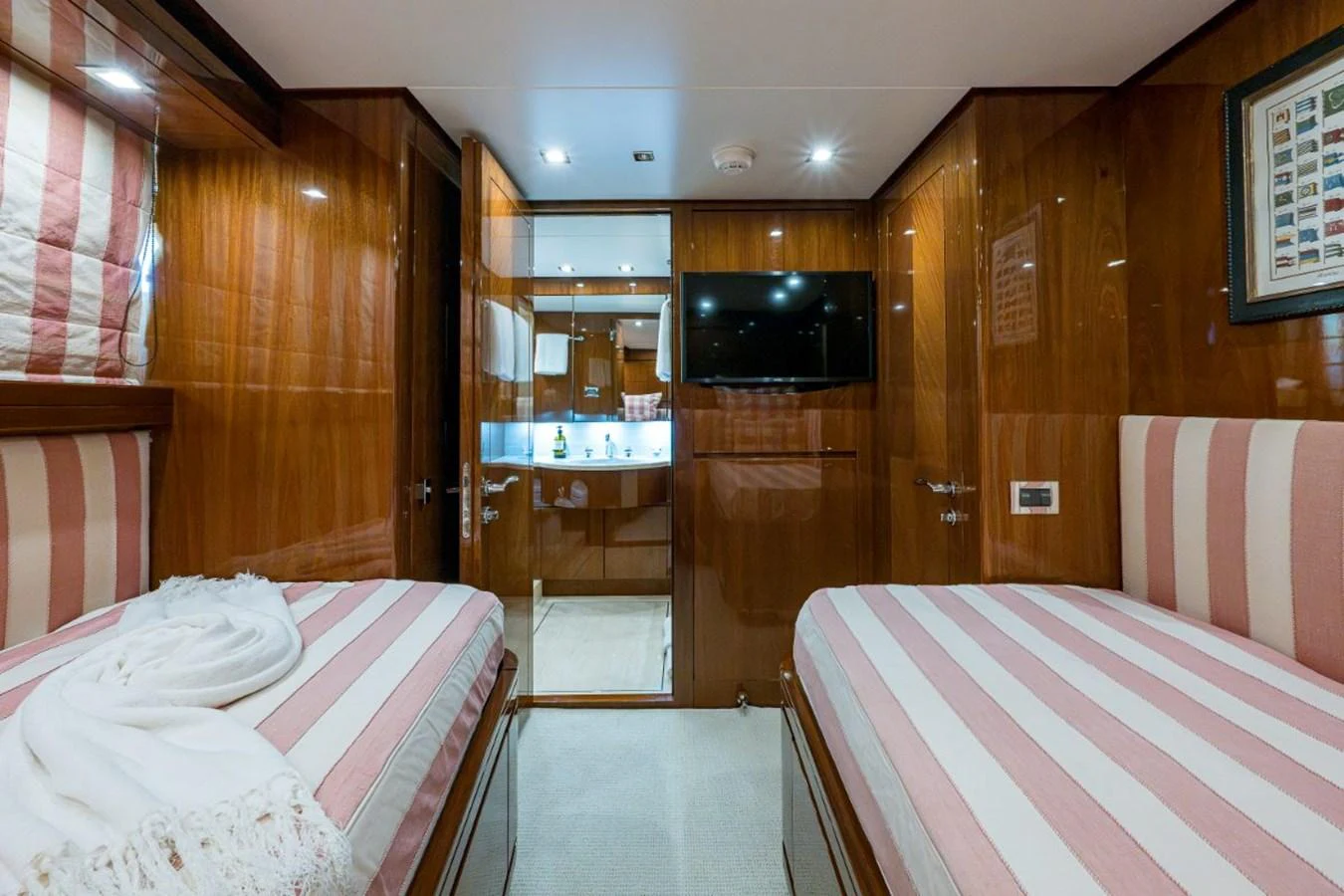 The twin stateroom features elegant wood paneling and comfortable striped bedding. aboard ALEGHI Yacht for Sale