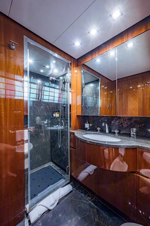 The yacht's bathroom features luxurious wood paneling and a sleek, modern shower. aboard ALEGHI Yacht for Sale