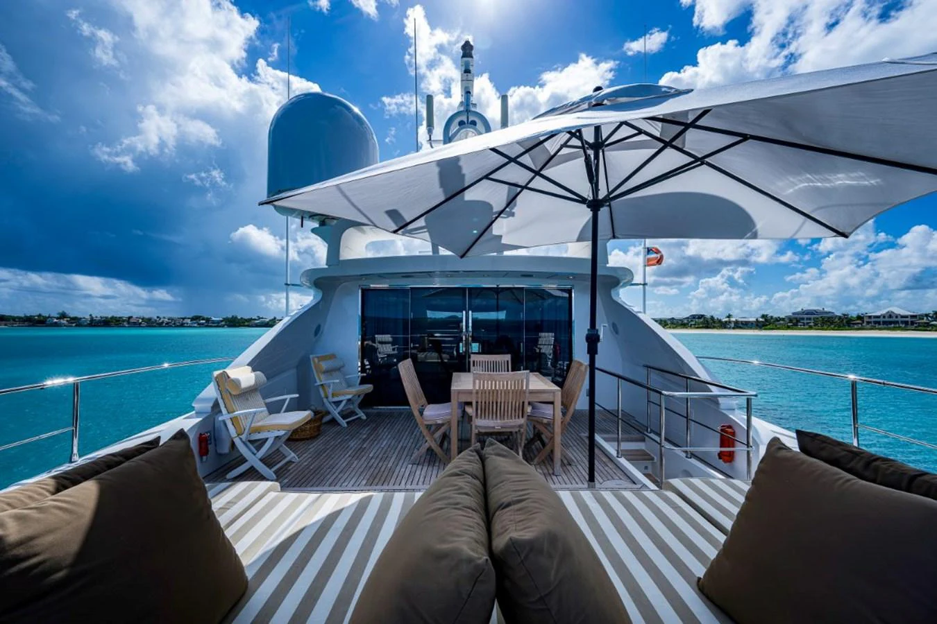 The sundeck offers a luxurious outdoor dining area with comfortable seating and a large umbrella for shade. aboard ALEGHI Yacht for Sale