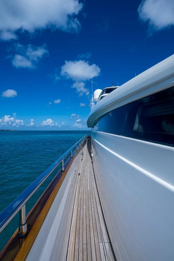 A sleek yacht cruising on calm blue waters under a clear sky. aboard ALEGHI Yacht for Sale