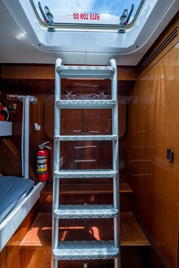 A well-lit interior space with a metal ladder leading to an overhead hatch. aboard ALEGHI Yacht for Sale