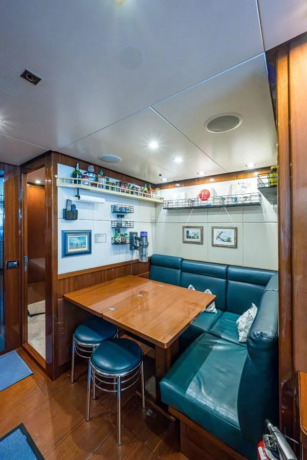 A cozy dining area with a wooden table and comfortable seating. aboard ALEGHI Yacht for Sale