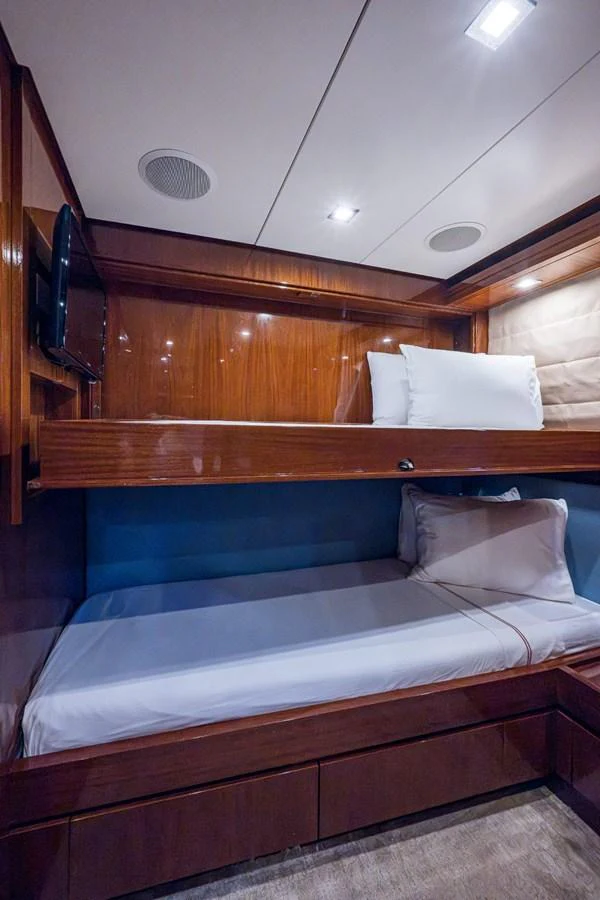 The guest cabin features cozy bunk beds with polished wood finishes and soft lighting. aboard ALEGHI Yacht for Sale