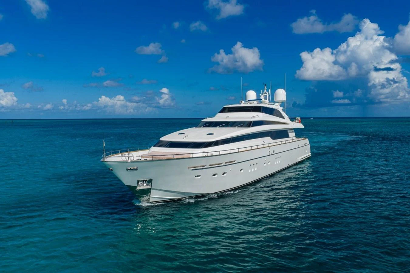 A sleek yacht glides through clear blue waters under a bright sky. aboard ALEGHI Yacht for Sale