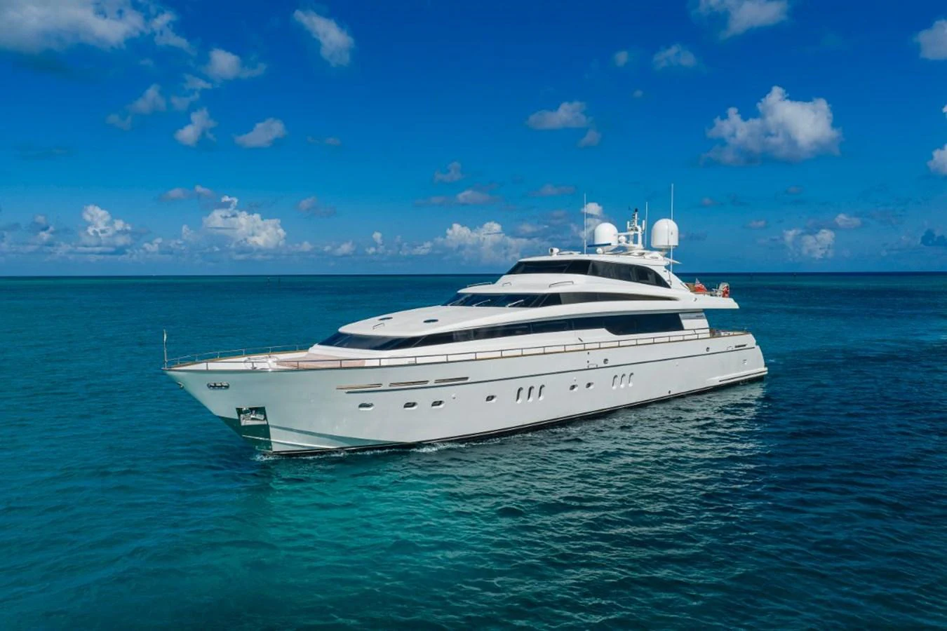 A sleek and modern yacht cruising on calm, clear blue waters under a bright sky. aboard ALEGHI Yacht for Sale