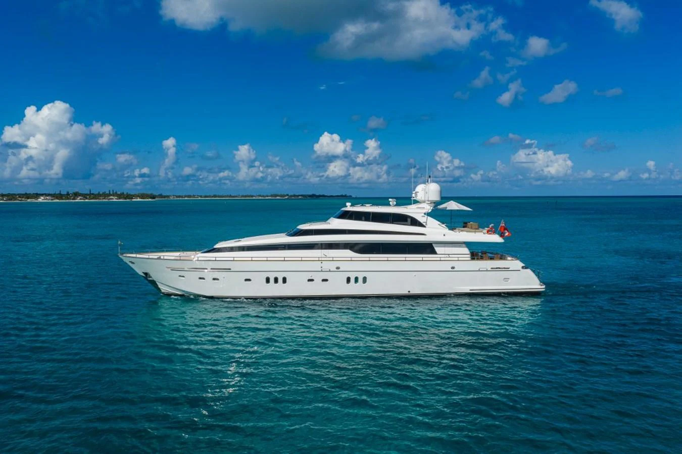 A sleek and elegant yacht cruising on calm, turquoise waters under a bright blue sky. aboard ALEGHI Yacht for Sale