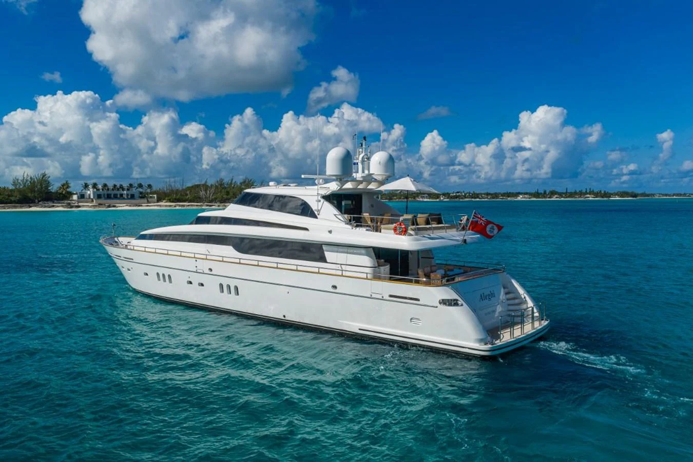 A sleek white yacht cruises through clear blue waters under a bright sky. aboard ALEGHI Yacht for Sale