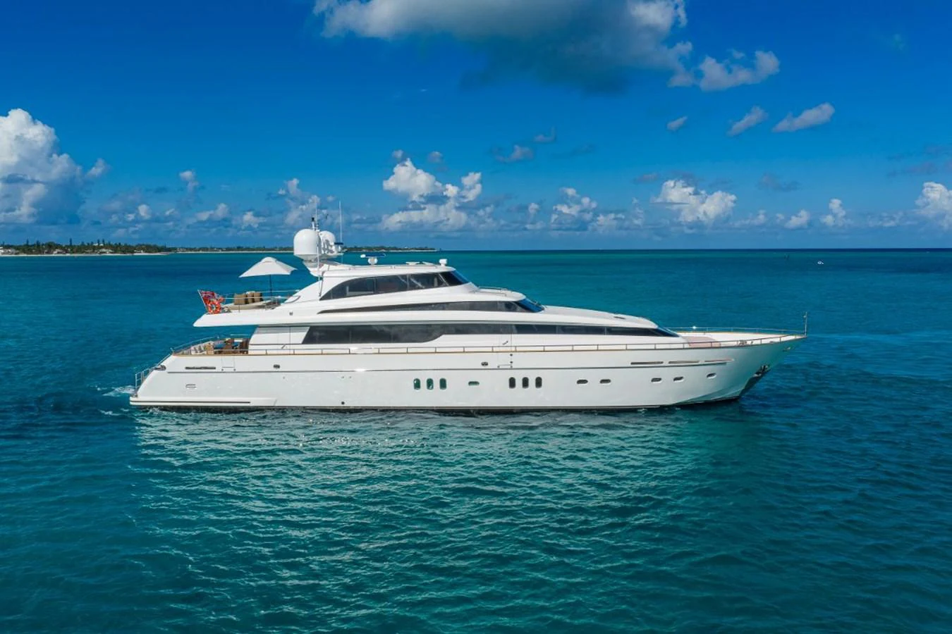 A sleek and elegant yacht cruising on calm, turquoise waters under a bright blue sky. aboard ALEGHI Yacht for Sale
