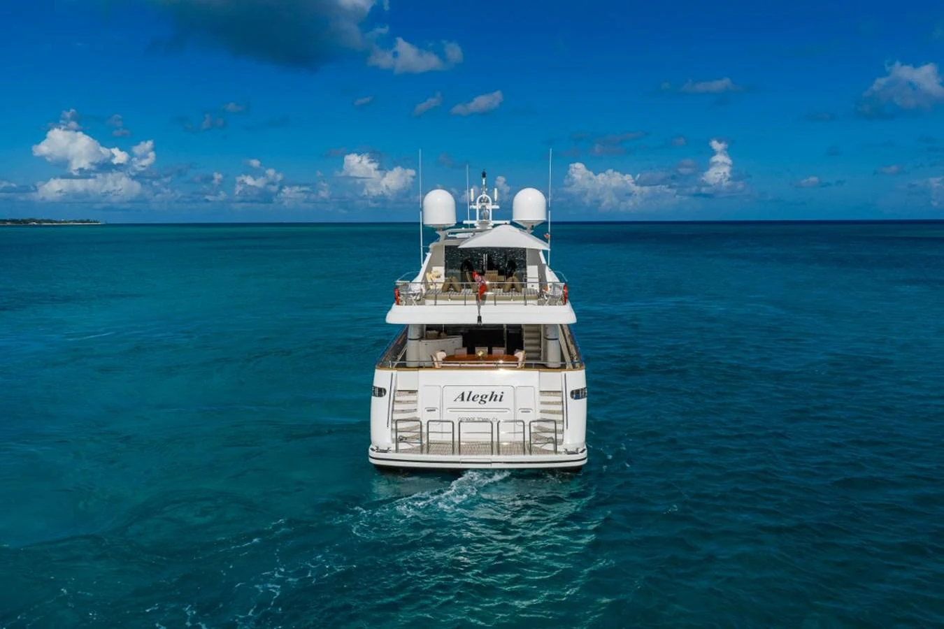 A luxurious yacht cruises through clear blue waters under a bright sky. aboard ALEGHI Yacht for Sale