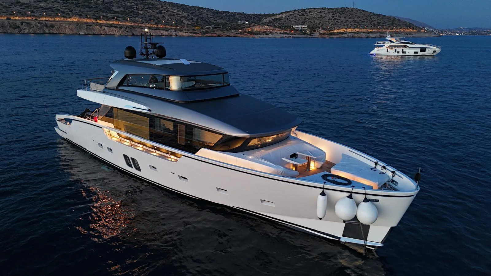 A sleek and modern yacht cruises gracefully on calm waters at dusk. aboard BELLA B Yacht for Sale