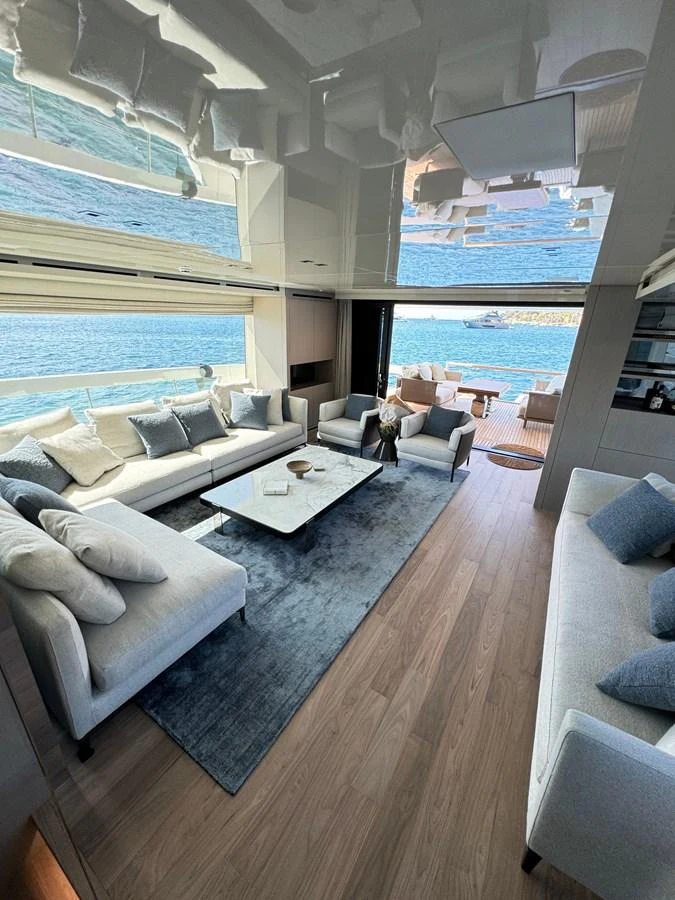 The yacht's salon features luxurious seating with a view of the water through large windows. aboard BELLA B Yacht for Sale