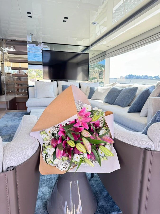 The salon features a comfortable seating area with a bouquet of flowers adding a touch of elegance. aboard BELLA B Yacht for Sale