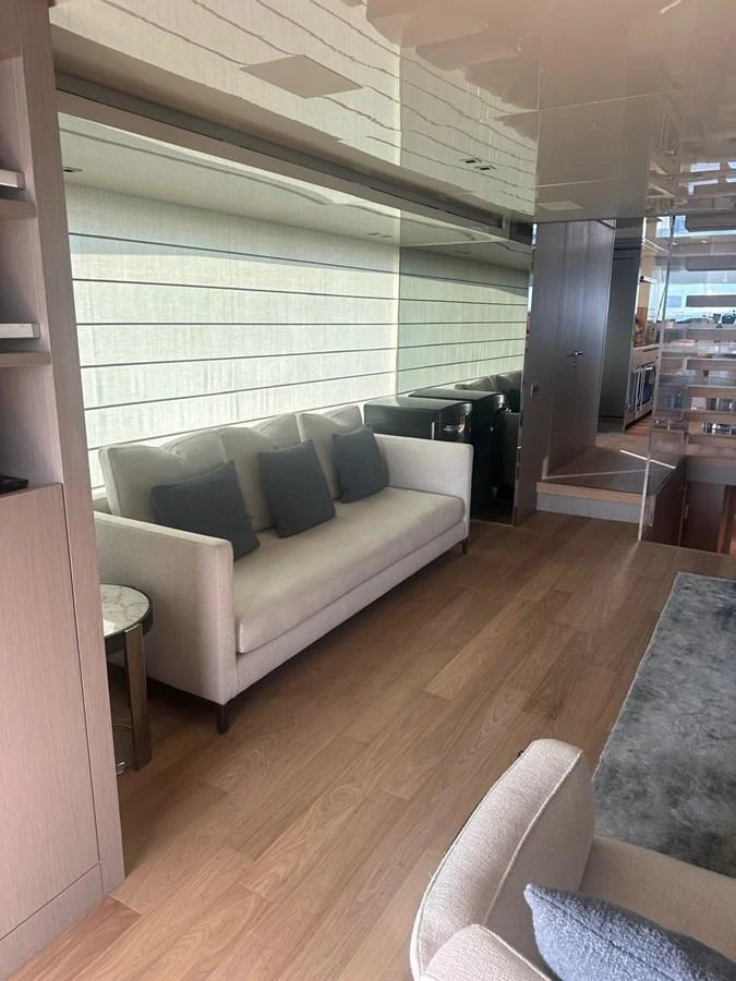 The yacht's interior features a cozy seating area with a modern sofa and stylish decor. aboard BELLA B Yacht for Sale
