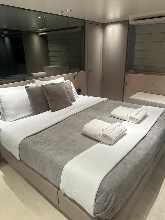 The stateroom features a plush bed with neatly arranged linens and pillows, exuding comfort and elegance. aboard BELLA B Yacht for Sale