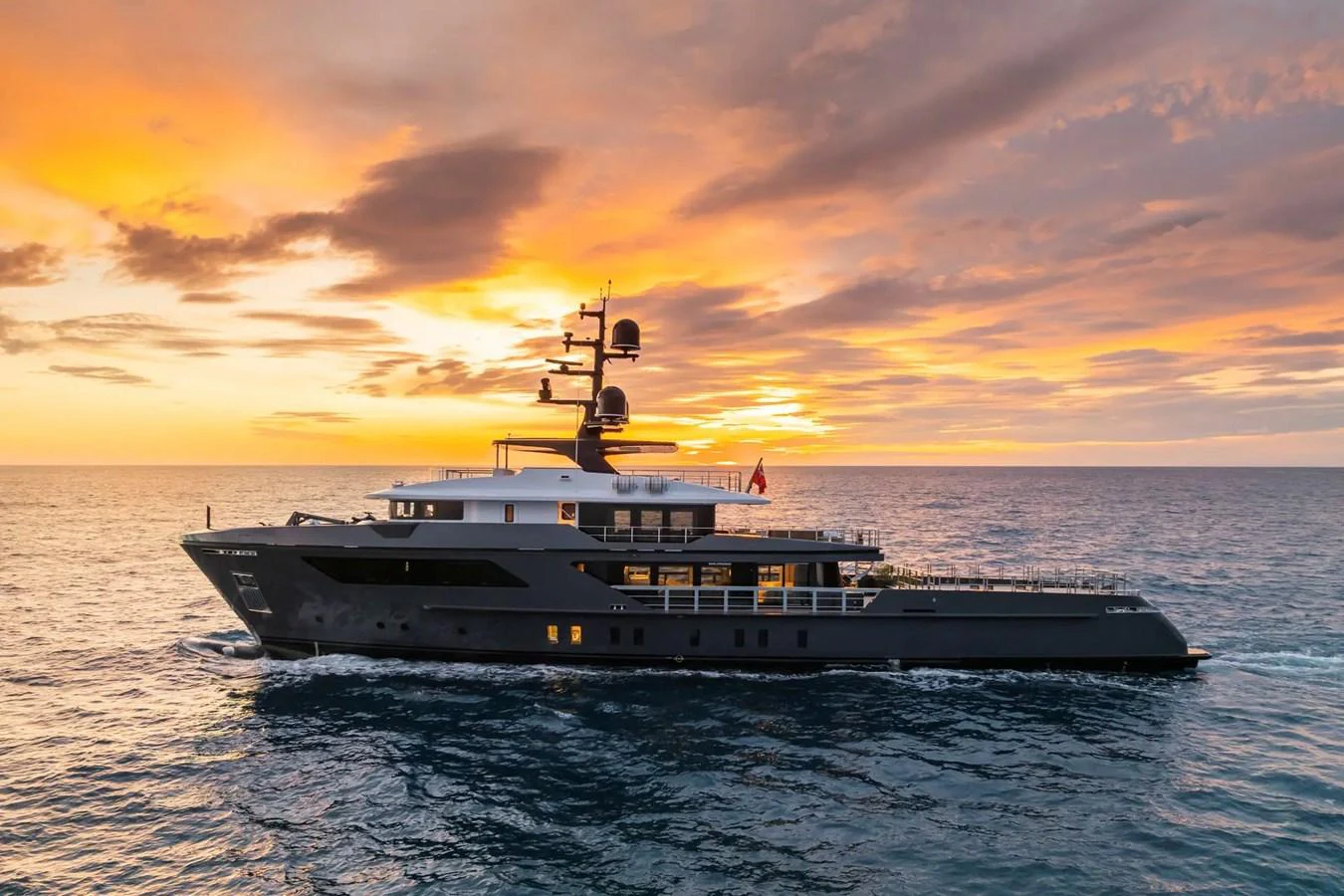 A sleek and modern yacht cruising at sunset, showcasing its elegant design against a stunning sky. aboard BIG SHARK Yacht for Sale