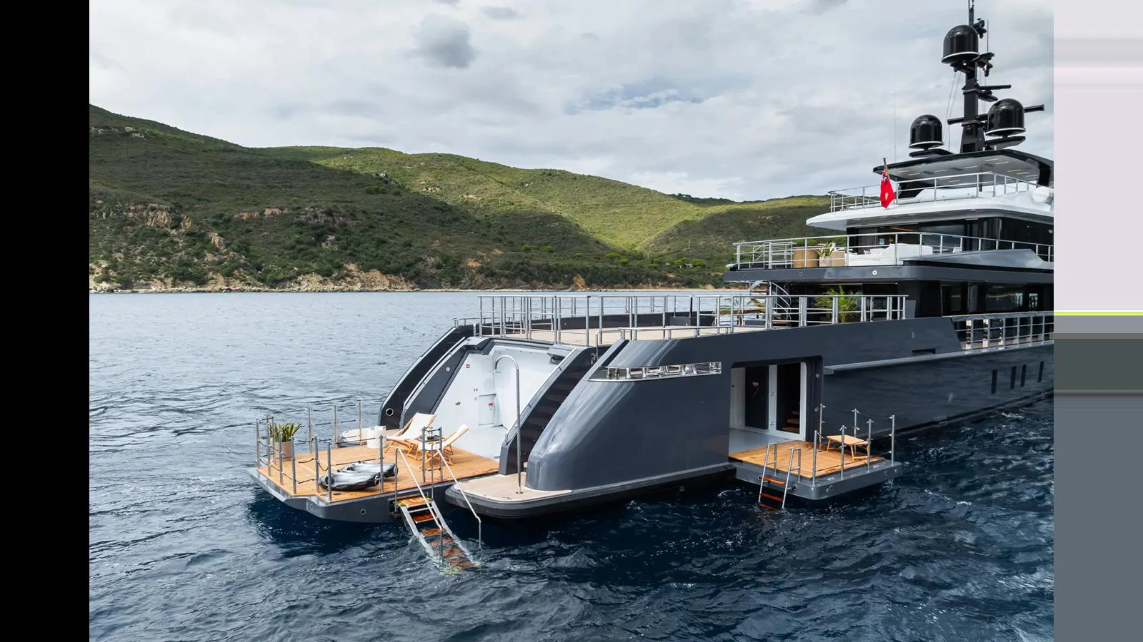 A sleek yacht with a modern design is anchored in a serene coastal area. aboard BIG SHARK Yacht for Sale